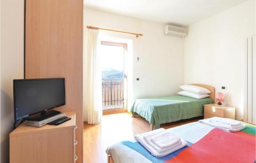 a small room with two beds and a television at Casa Cesarina in Raveo