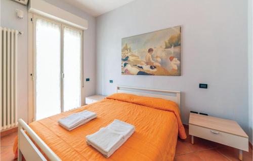 1 dormitorio con 1 cama de color naranja y una pintura en la pared en Orizzonte 1, en Lido di Dante