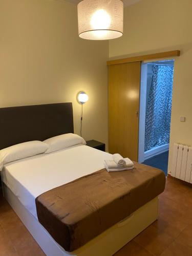 - une chambre avec un grand lit et une fenêtre dans l'établissement Hostal Alaska, à Madrid