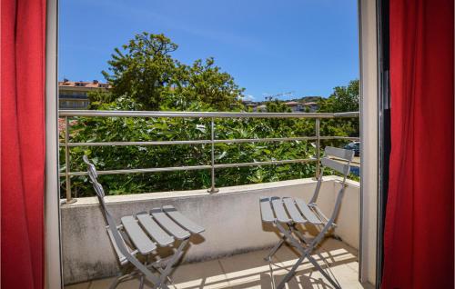 two chairs sitting on a balcony looking out a window at Gorgeous Apartment In Propriano in Propriano