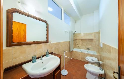 bagno con lavandino, servizi igienici e specchio di La Terrazza a Porto Torres