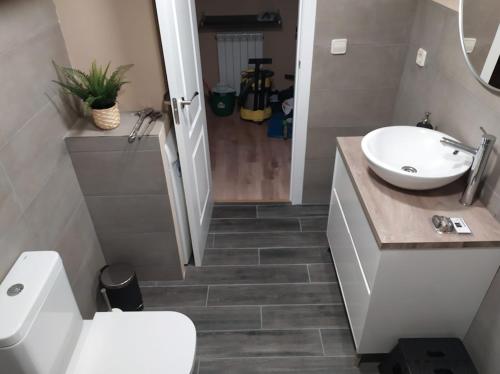 a bathroom with a white sink and a toilet at CHECK-IN CASAS El rinconet in Cerler