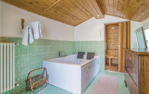 a bathroom with a white tub and green tiles at Nice Home In Santagata Feltria Rn With Kitchen in SantʼAgata Feltria