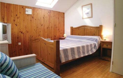 sypialnia z łóżkiem, drewnianymi ścianami i drewnianą podłogą w obiekcie Awesome Home In Lhermenault With Heated Swimming Pool w mieście LʼHermenault