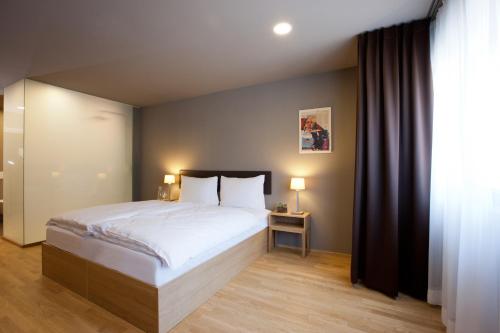 ein Schlafzimmer mit einem großen Bett und einem Fenster in der Unterkunft Hotel am Garnmarkt in Götzis