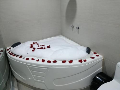 a white bath tub with red flowers on it at Hotel Burj Khalifa in Quillabamba