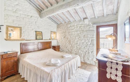 ein Schlafzimmer mit einem Bett und einer Steinmauer in der Unterkunft 2 Bedroom Pet Friendly Home In Cortona Ar in Polvano