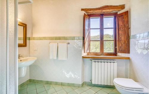 baño con aseo y lavabo y ventana en La Capannina, en Radicondoli