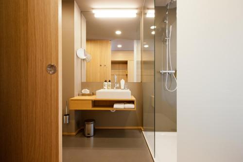 a bathroom with a sink and a shower at Hotel am Garnmarkt in Götzis