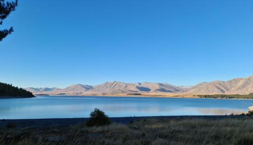 a lake with mountains and a mountain range at Mantra Lake Tekapo in Lake Tekapo