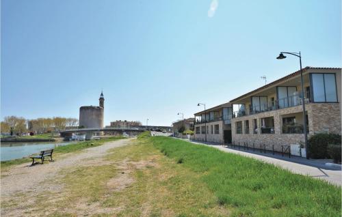 a park next to a river with buildings and a bench at Gorgeous Apartment In Aigues-Mortes in Aigues-Mortes