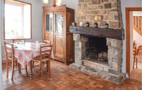 une salle à manger avec une table et une cheminée dans l'établissement 2 Bedroom Lovely Home In Kerbors, à Kerbors