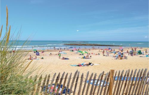 Une foule de gens sur une plage avec l'océan dans l'établissement Nice Home In St Maixent Sur Vie, à Saint-Maixent-sur-Vie