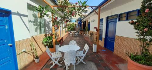 a patio with a table and chairs and plants at Casa Hostal Luna Llena in Cartagena de Indias