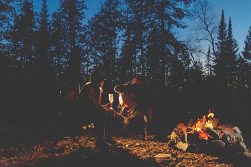 a person is standing next to a fire at Entre Lemoine et l'arbre in Val-dʼOr