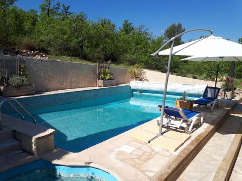 una piscina con sedia e ombrellone di Maison de 3 chambres avec piscine partagee jardin clos et wifi a Mons a Mons
