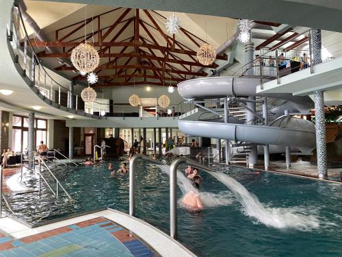 a large indoor swimming pool with people in the water at Apartment Family Besenova - free pool in Bešeňová