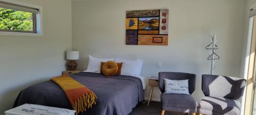 a bedroom with a bed and a chair at Lodges On Pearson Unit 1 in Cromwell