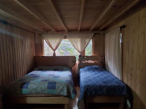 2 camas en una habitación pequeña con ventana en Acogedora pieza privada en casa frente al mar y al parque el Pudu, en San Antonio de Chadmo