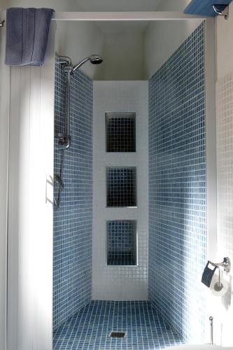 a bathroom with a shower with blue tiles on the wall at La Nuova Girgenti in Agrigento