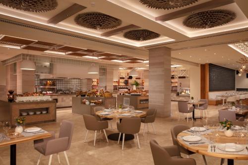 a restaurant with tables and chairs and a kitchen at Breathless Cancun Soul Resort & Spa - Adults Only - All Inclusive in Cancún