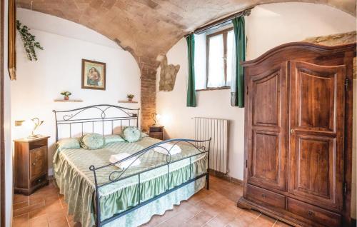 UlignanoにあるStunning Apartment In Prato Dera Pi With 1 Bedrooms, Wifi And Outdoor Swimming Poolのベッドルーム1室(ベッド1台、大きな木製クローゼット付)