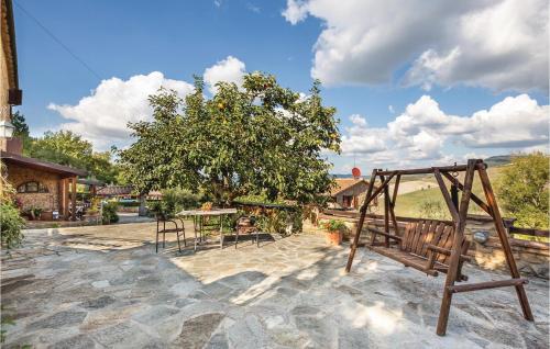 a patio with a tree and a wooden swing at Lovely Apartment In Prato Dera Pi in Ulignano