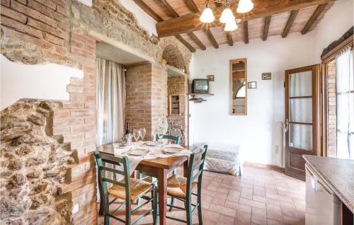 a dining room with a brick wall and a table and chairs at Lovely Apartment In Prato Dera Pi in Ulignano