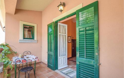 サン・ジョルジョにあるBeautiful Apartment In Gioiosa Marea Me With 1 Bedrooms, Wifi And Outdoor Swimming Poolのテーブルと緑のドア付きの部屋