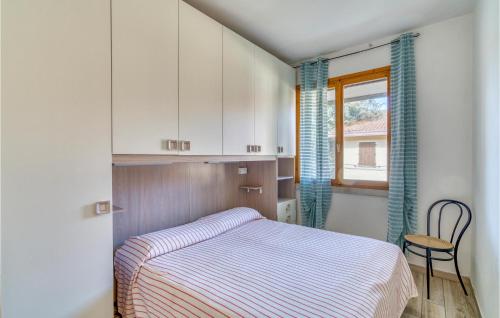 ロゾリーナ・マーレにあるCacciatore Biloのベッドルーム1室(ベッド1台、椅子、窓付)