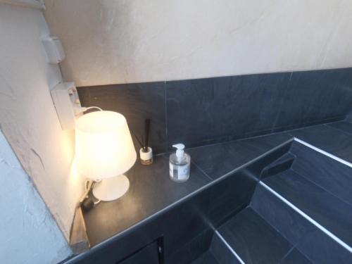 a blue tiled bathroom with a lamp on a counter at Mini Apartamento de Lujo in Becerril de la Sierra