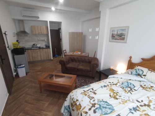 een slaapkamer met een bed, een bank en een tafel bij Mini Apartamento de Lujo in Becerril de la Sierra