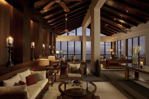 a living room with a couch and chairs and a table at The Leela Kovalam, A Raviz Hotel in Kovalam