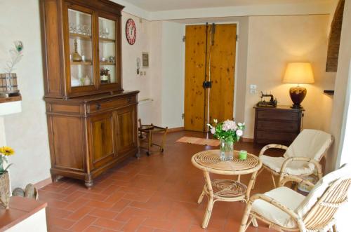 uma sala de estar com mesa e cadeiras e um armário em La Casetta di Barbara em Impruneta