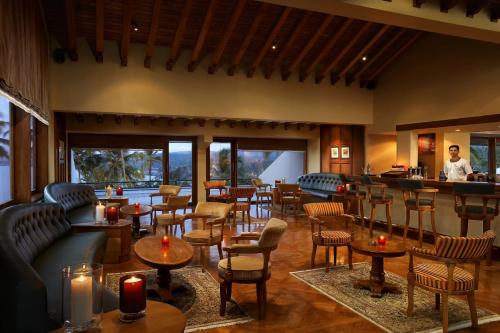 a restaurant with tables and chairs and a bar at The Leela Kovalam, A Raviz Hotel in Kovalam