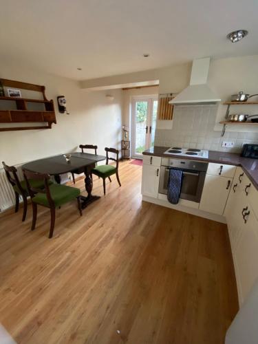 a kitchen with a table and a dining room at Fern Cottage Iden, Rye in Iden