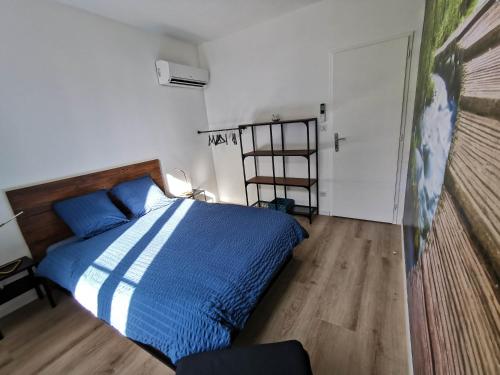 1 dormitorio con 1 cama con sábanas azules y blancas en Le temps d'une pause'', 