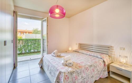 1 dormitorio con cama y ventana grande en 2 Bedroom Beautiful Apartment In Puegnago Sul Garda, en Raffa
