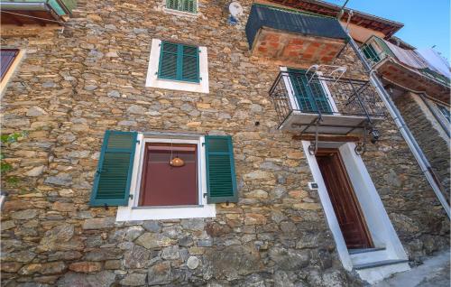 un edificio de piedra con persianas verdes y una puerta en Pet Friendly Apartment, en Borghetto dʼArroscia