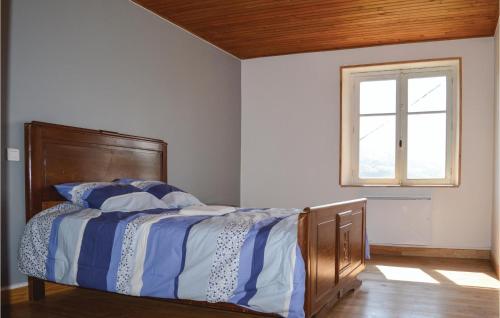 een slaapkamer met een bed met blauwe en witte lakens en een raam bij 3 Bedroom Beautiful Home In Cheylade in Cheylade