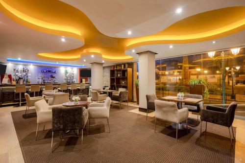a restaurant with tables and chairs and a yellow ceiling at Sonesta Hotel Cusco in Cusco