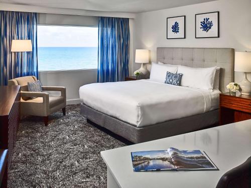 a hotel room with a bed and a view of the ocean at Sonesta Fort Lauderdale Beach in Fort Lauderdale