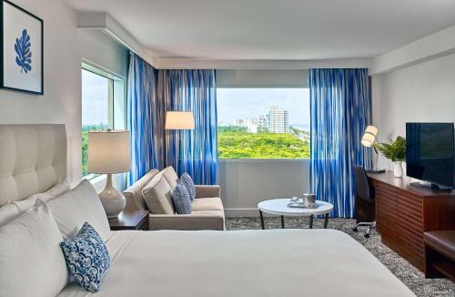 a hotel room with a bed and a window at Sonesta Fort Lauderdale Beach in Fort Lauderdale