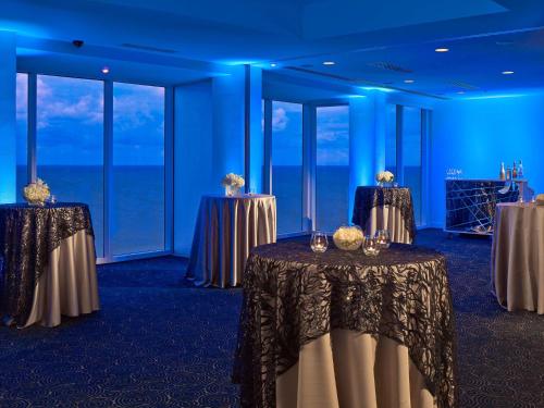 a row of tables in a room with blue lights at Sonesta Fort Lauderdale Beach in Fort Lauderdale