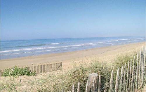 une plage de sable avec une clôture et l'océan dans l'établissement Lovely Home In St Urbain With Kitchen, à Saint-Urbain