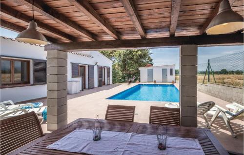 a patio with a pool and a table and chairs at 3 Bedroom Nice Home In Vidreres in Vidreres