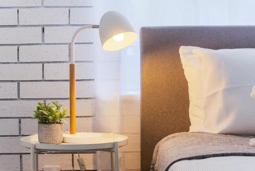 a lamp on a table next to a bed at The Arches ~ Style, location and spacious living! in McLaren Vale