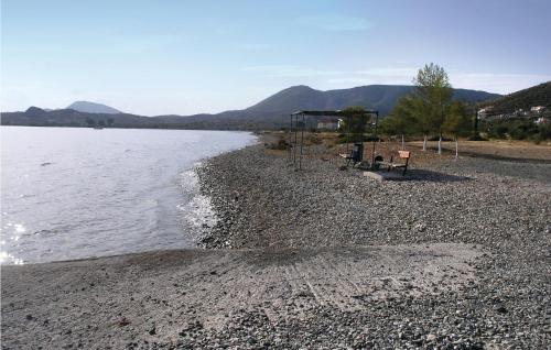 a rocky beach with a bench and the water at Soleiliosonne Haus Europa in Ermioni