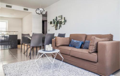 un salon avec un canapé marron et une table dans l'établissement Cozy Apartment In Los Arenales Del Sol, à Arenales del Sol