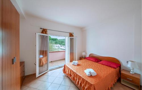 a bedroom with a bed and a large sliding glass door at Stunning Apartment In La Maddalena With House A Panoramic View in La Maddalena